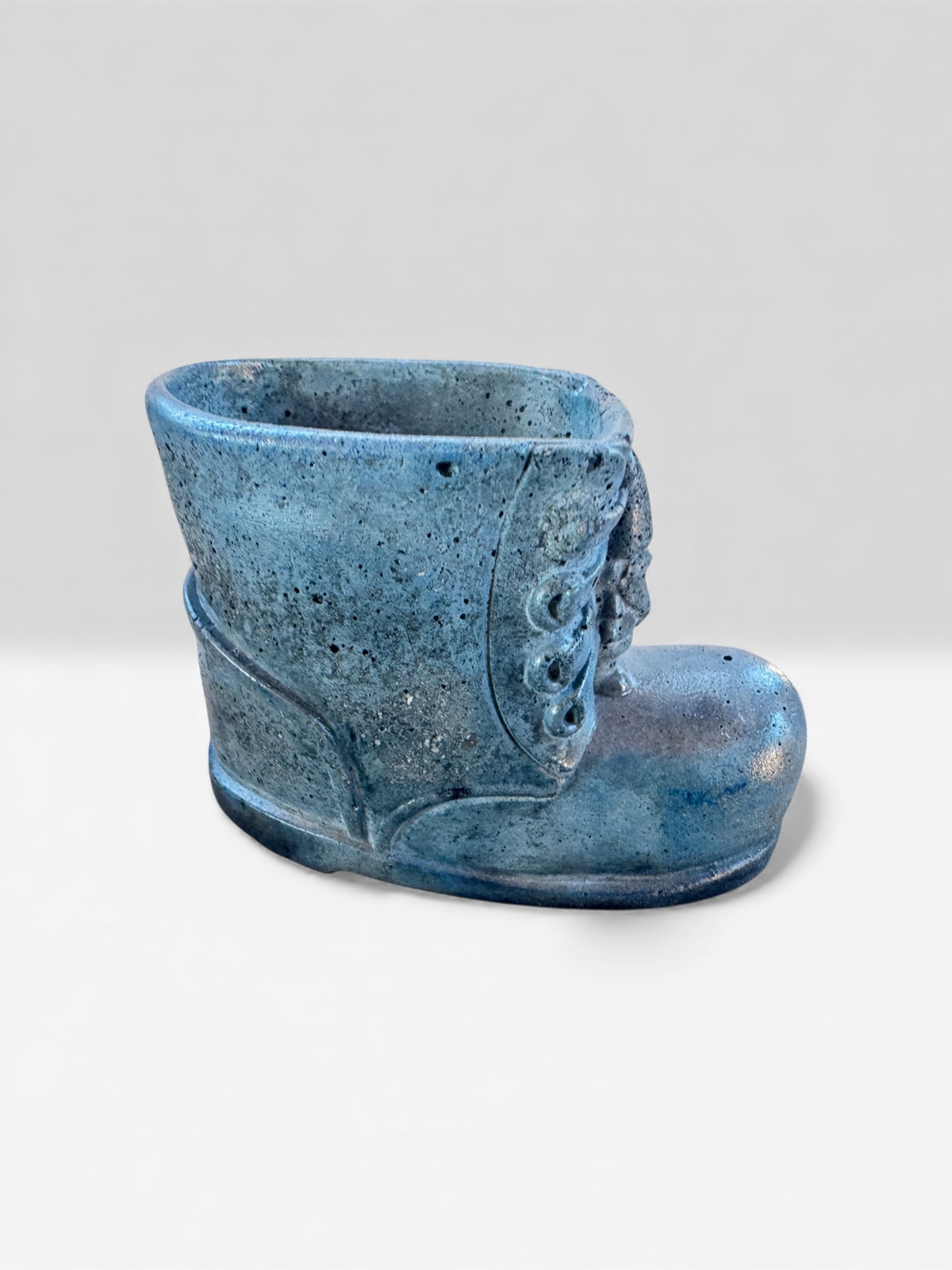 Whimsical concrete plant pot shaped like a work boot
